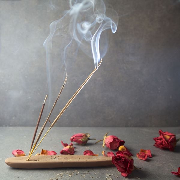 Incense sticks burning rose petals